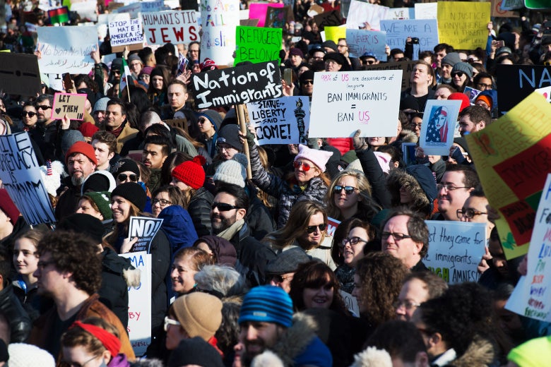Protesters hold up signs like, "Nation of Immigrants."